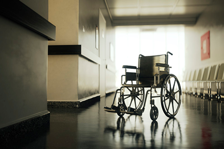 Standard manual wheelchair standing in empty hospital corridor